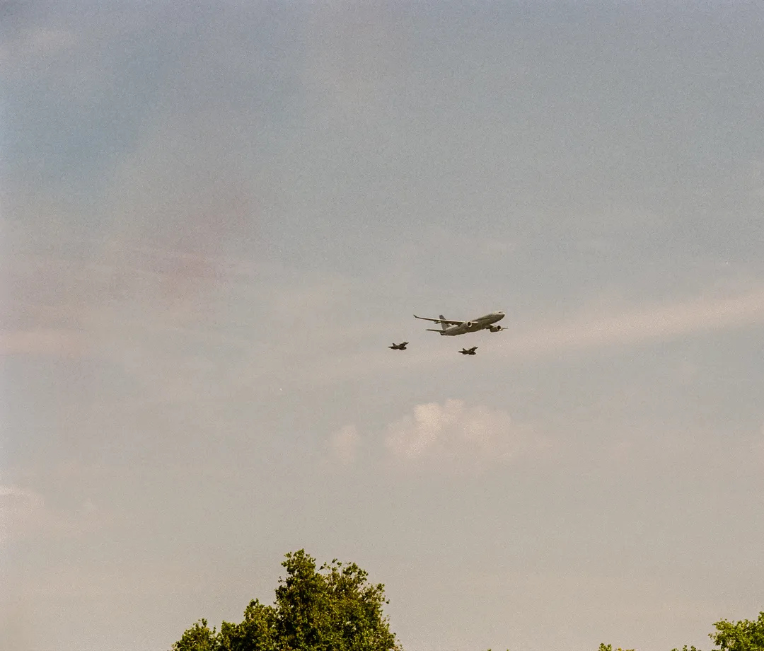 Passenger aircraft and two smaller aircraft crossing a pale sky over Paris